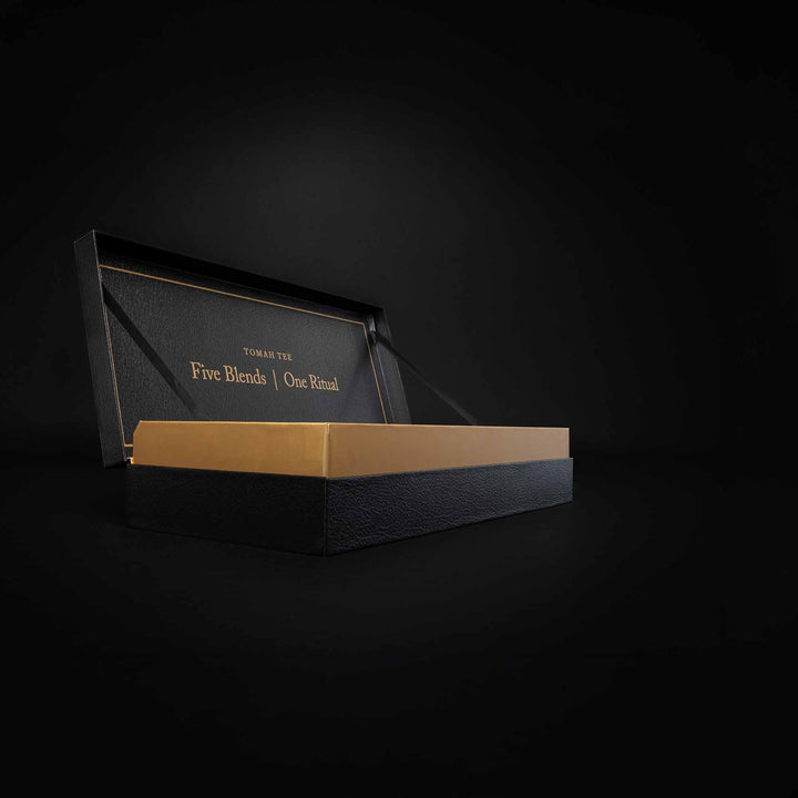 Geöffnete Tomah Tee BIO Geschenkbox in Schwarz und Gold mit hochwertiger Einlage für fünf Bio-Teedosen